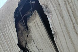 Vrachtwagen met te hoge kraan slaat gat in onderkant viaduct