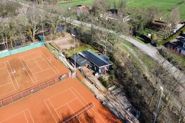 Schade door brand bij tennisvereniging bij daglicht goed zichtbaar door dronefoto's
