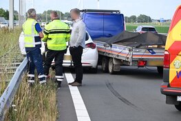 Auto tussen vangrail gedrukt door bedrijfsbusje in Alkmaar