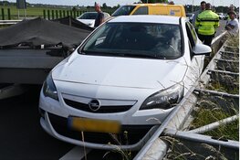 Auto tussen vangrail gedrukt door bedrijfsbusje in Alkmaar