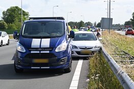 Auto tussen vangrail gedrukt door bedrijfsbusje in Alkmaar