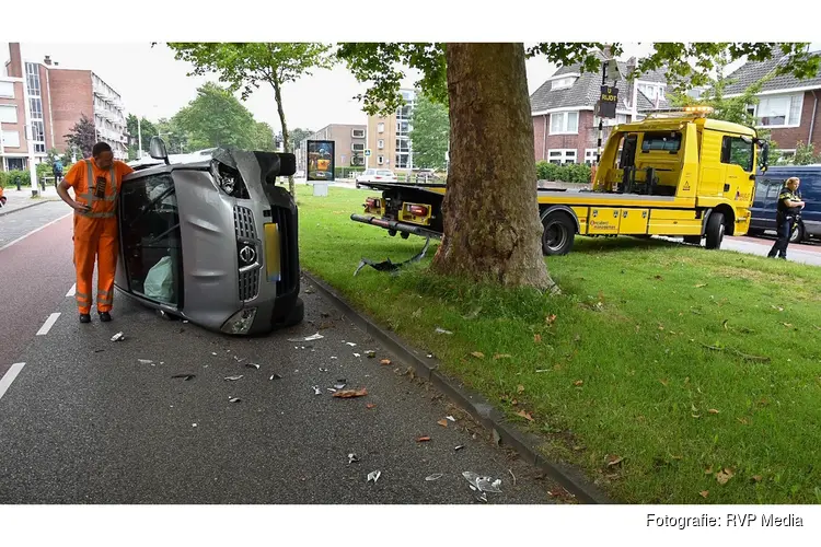 Auto belandt op zijn kant na aanrijding met boom