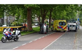 Auto belandt op zijn kant na aanrijding met boom