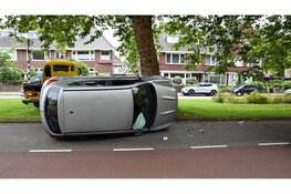Auto belandt op zijn kant na aanrijding met boom