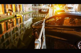 Auto hangt boven gracht na botsing in Alkmaar: bestuurder aangehouden voor rijden onder invloed