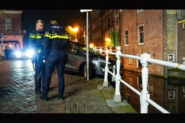 Auto hangt boven gracht na botsing in Alkmaar: bestuurder aangehouden voor rijden onder invloed