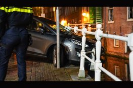 Auto hangt boven gracht na botsing in Alkmaar: bestuurder aangehouden voor rijden onder invloed