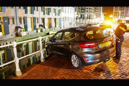 Auto hangt boven gracht na botsing in Alkmaar: bestuurder aangehouden voor rijden onder invloed